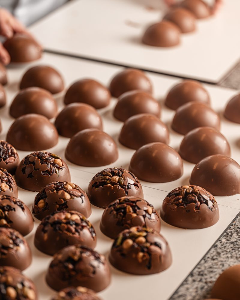 Rows of chocolate domes filled with nuts and dried fruit